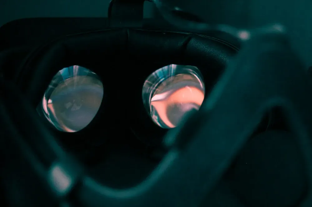 A close-up view into the glowing lenses of a dark VR headset.